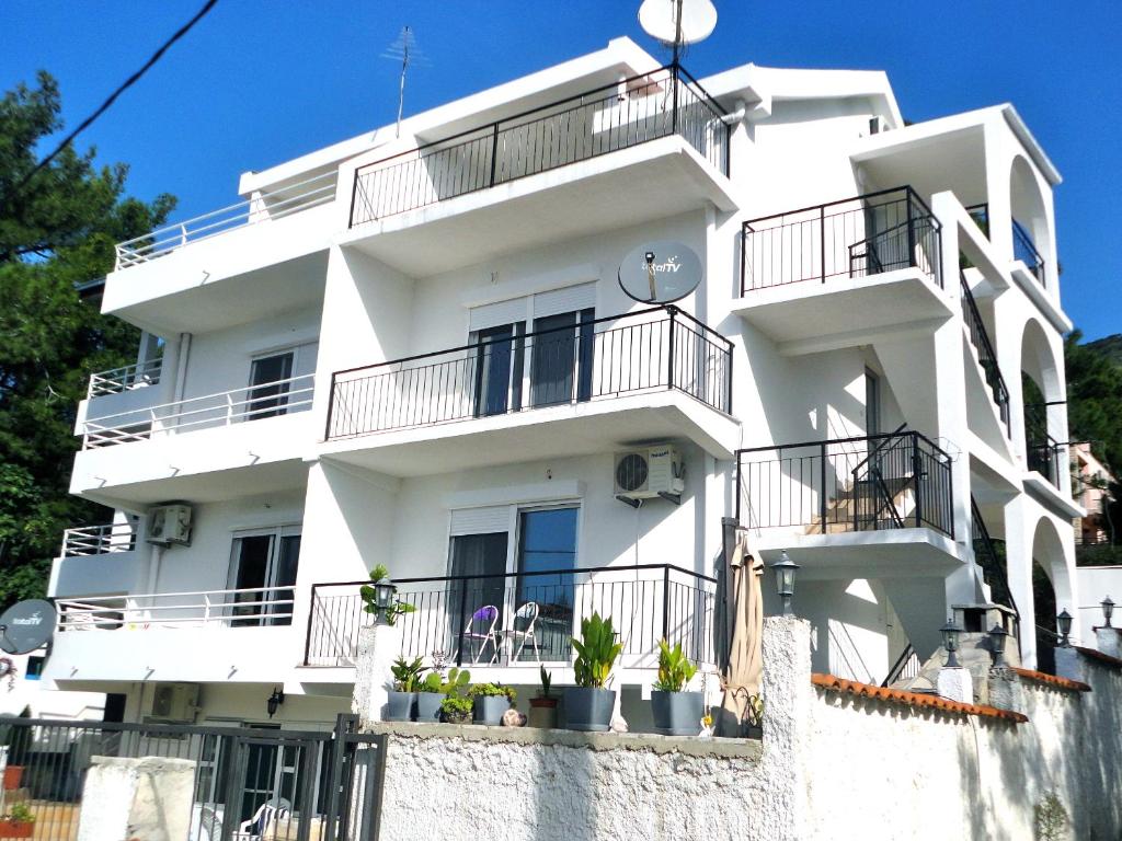 biały budynek z balkonami i roślinami na nim w obiekcie Apartments Ljiljana w Barze