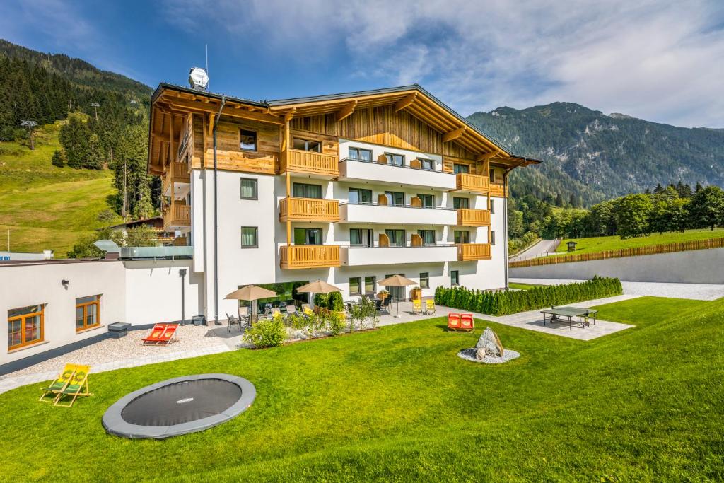 an apartment building with a lawn in front of it at OFENTÜRL alpine living in Flachau