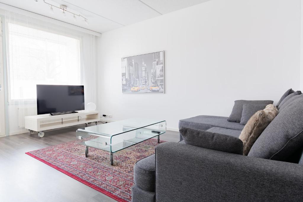 - un salon avec un canapé et une table basse dans l'établissement Torget Apartment Laululinna, à Pori