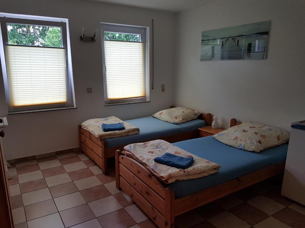a room with three beds and two windows at Gästezimmer auf dem Campingplatz Konz in Konz