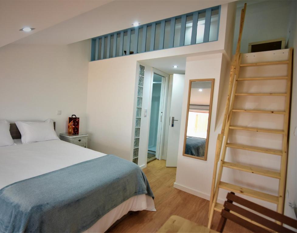 a bedroom with a bed with a ladder and a staircase at Casa da Avó Lurdes in Póvoa de Varzim