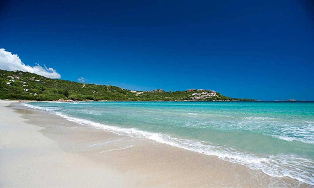 een strand met de oceaan en een blauwe lucht bij Marinella, Sardegna in Marinella