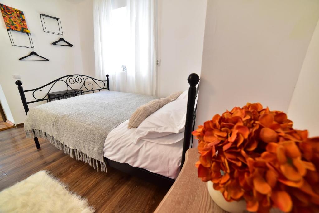 - une chambre avec un lit et un vase de fleurs sur une table dans l'établissement FLH - Emma Apartment, à Sibiu