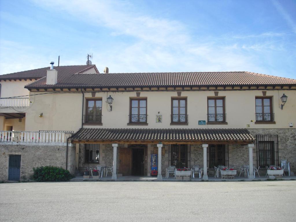 a large building with tables and chairs in front of it at El Andarrio in Buitrago del Lozoya