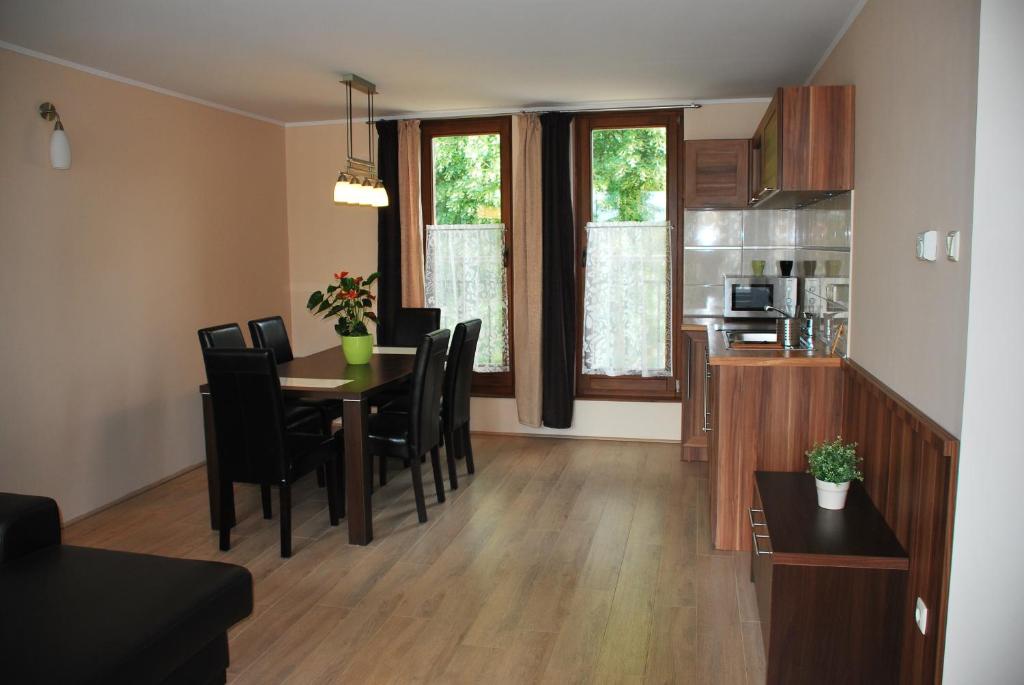 uma sala de jantar e cozinha com mesa e cadeiras em Albatrosz Apartman em Gyula