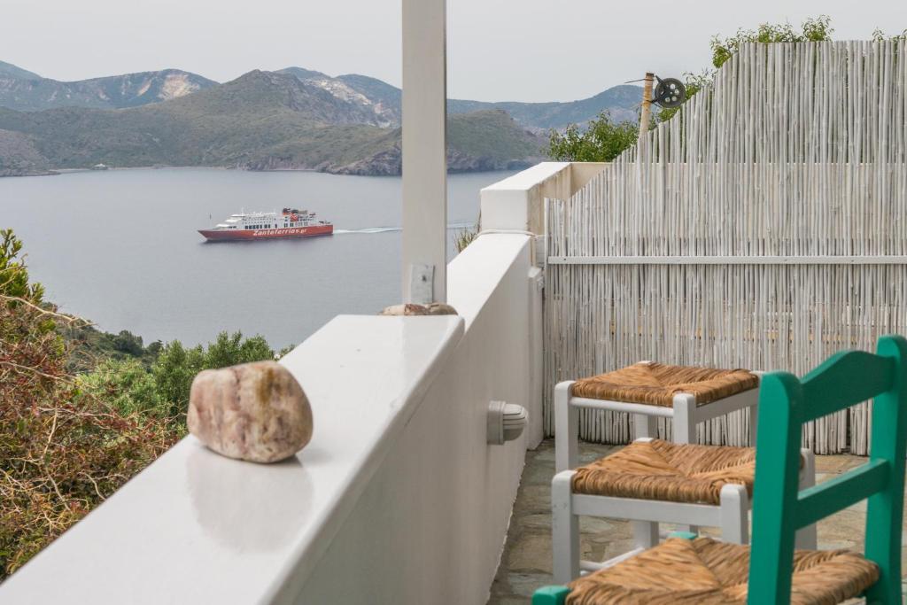 een balkon met 2 stoelen en een boot in het water bij Zanart Maisonette in Tripití