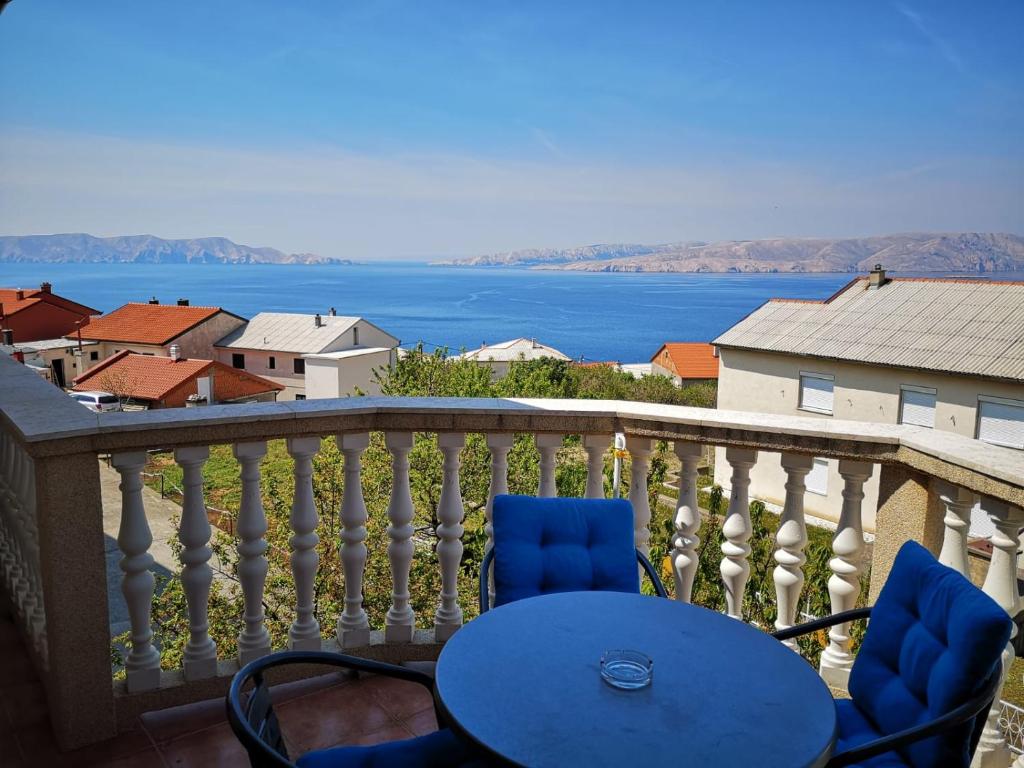 a table and chairs on a balcony with a view of the water at Guest House Angela in Senj