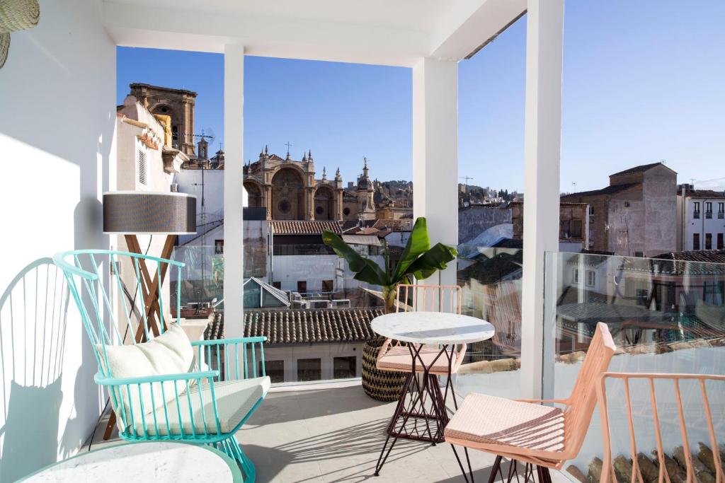 d'un balcon avec des chaises et une table offrant une vue sur la ville. dans l'établissement U-Sense Granada Catedral, à Grenade