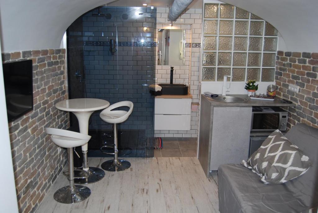 cocina con mesa y 2 taburetes en una habitación en La petite Piaule - 132, en Rouen
