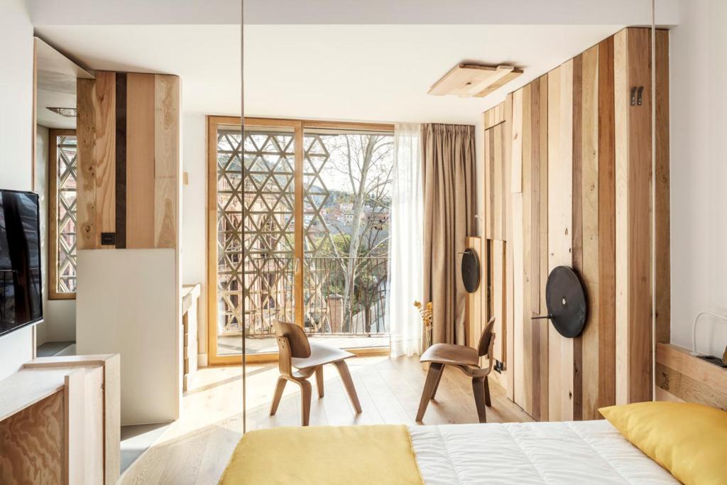 a bedroom with a bed and a kitchen with a window at Somiatruites in Igualada