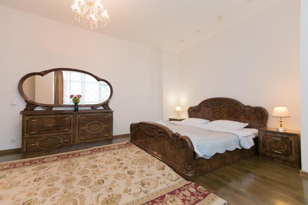 - une chambre avec un grand lit et un miroir dans l'établissement Diplomat Apartment on Sarayshyq st 34, à Astana