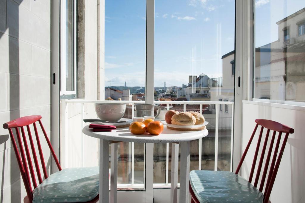 a table with two chairs and a table with oranges on it at Light Lovers Apartment in Lisbon