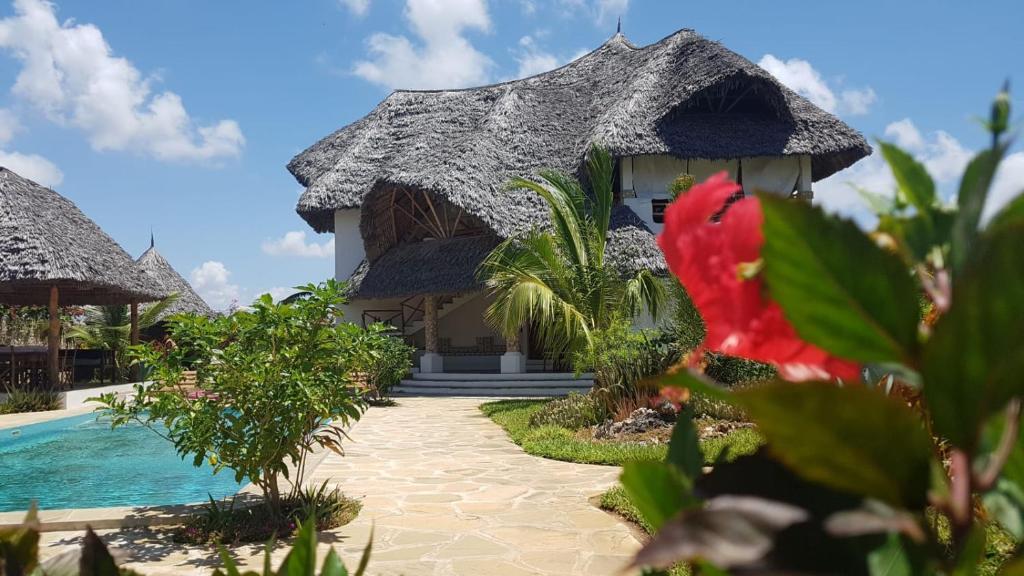 a resort with a swimming pool and a building at Nyumba Nicole in Watamu