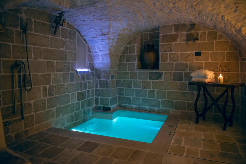La salle de bains est pourvue d'une baignoire et d'un mur en pierre. dans l'établissement Relais l’Antico Pozzo, à Martina Franca