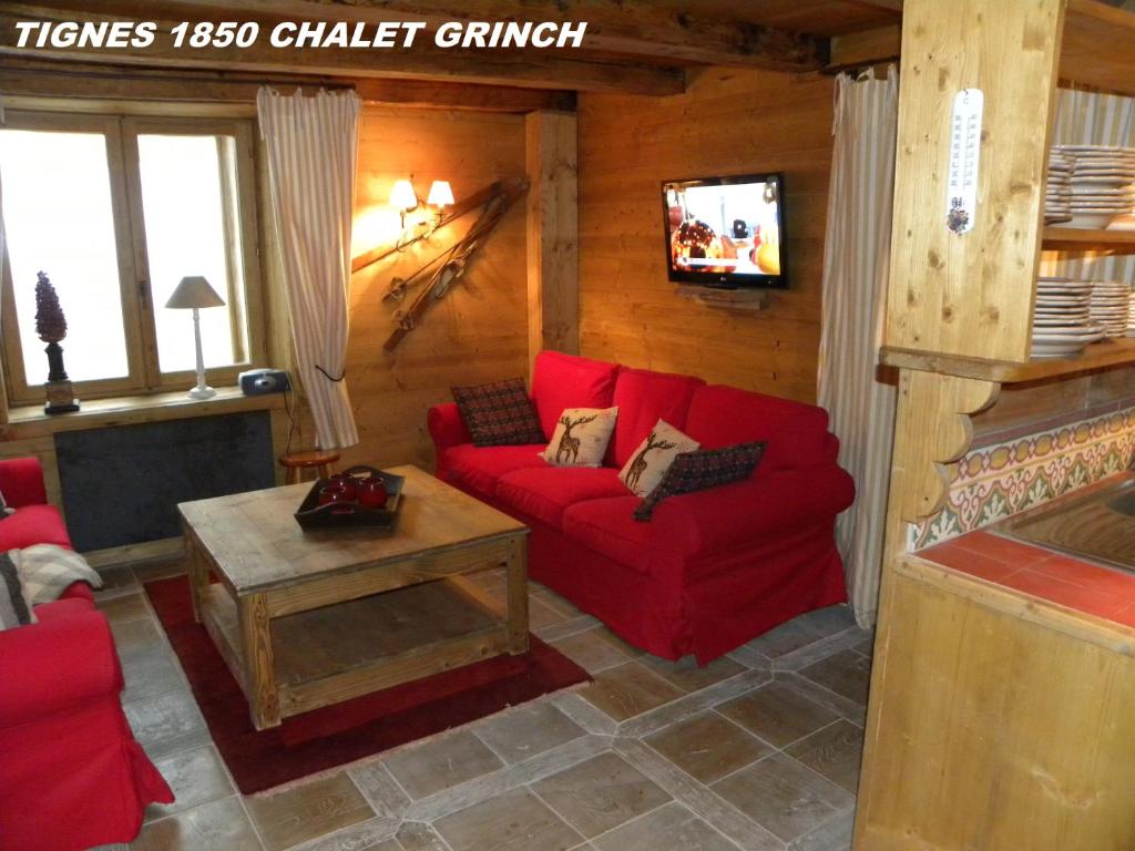 ein Wohnzimmer mit einem roten Sofa und einem Kamin in der Unterkunft CHALET GRINCH 90m2, 3 Sdb, skis aux pieds, wifi in Tignes