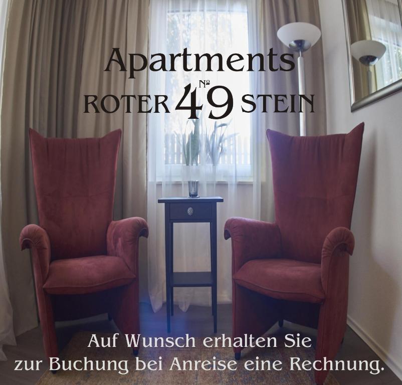 zwei rote Stühle neben einem Tisch mit Fenster in der Unterkunft Apartment am Roten Stein in Erfurt