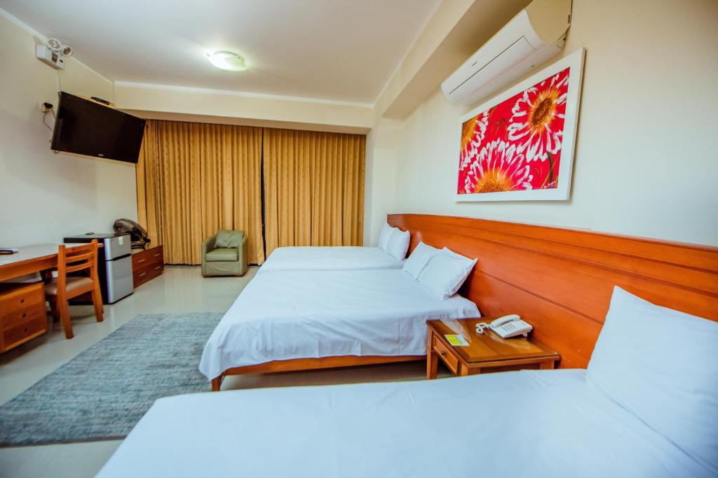 瓦努科Grima Hotel的有两张床和一张书桌的酒店房间
