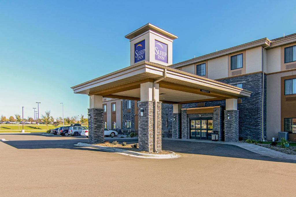 ein Gebäude mit einem Uhrturm auf einem Parkplatz in der Unterkunft Sleep Inn & Suites West-Near Medical Center in Rochester