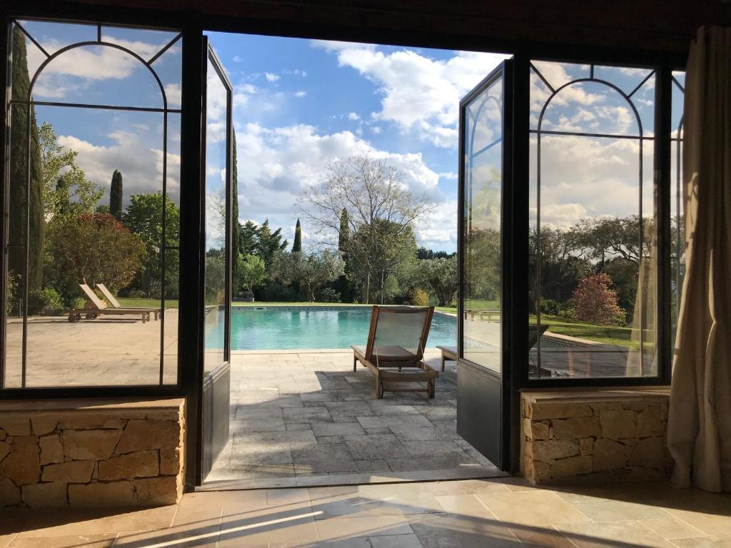 a room with a view of a pool through a door at LES BARTAVELLES in Aix-en-Provence