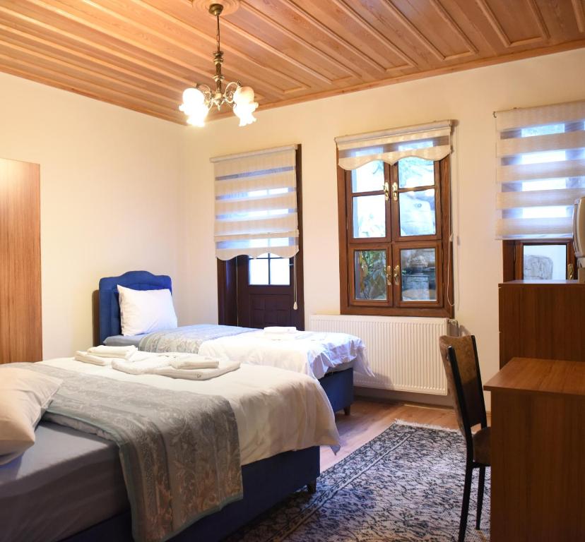 a bedroom with two beds and two windows at ÖZ Butik Otel Antik Kent Myrleia in Mudanya