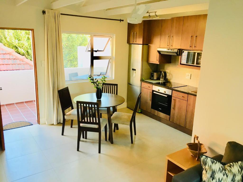 een keuken en eetkamer met een tafel en stoelen bij Kilkenny Cottages 2 bedroom unit in Johannesburg