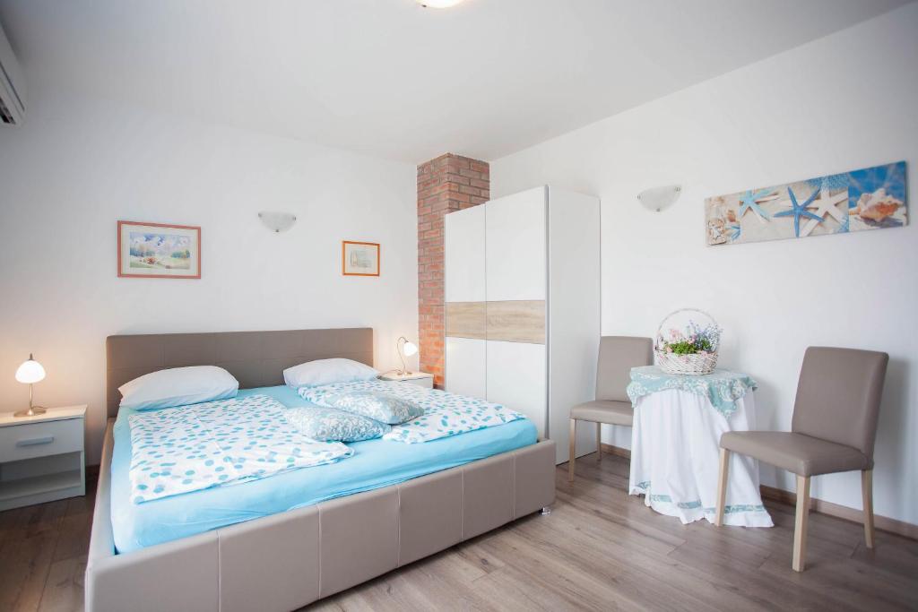 a bedroom with a bed and a table and a chair at Apartment Studio sole in Rovinj