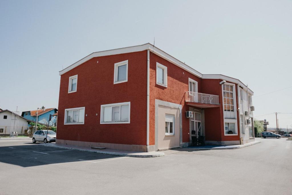 a red brick building with a car parked next to it at Guest House Sv. Nikola in Dugo Selo