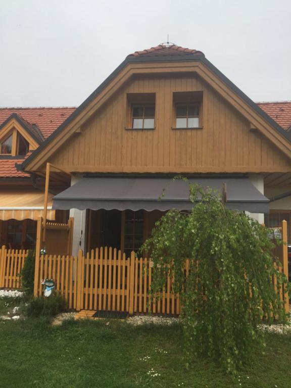 una casa con una valla de madera delante de ella en Apartma Jelenček, en Moravske Toplice