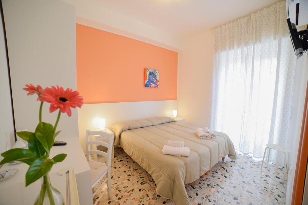 a bedroom with a bed and a vase with a flower at B&B Siracusa Holidays in Syracuse