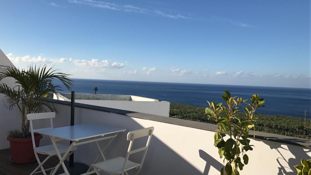 a table and chairs on a balcony overlooking the ocean at Apartamento Atico Guanchita in Tazacorte