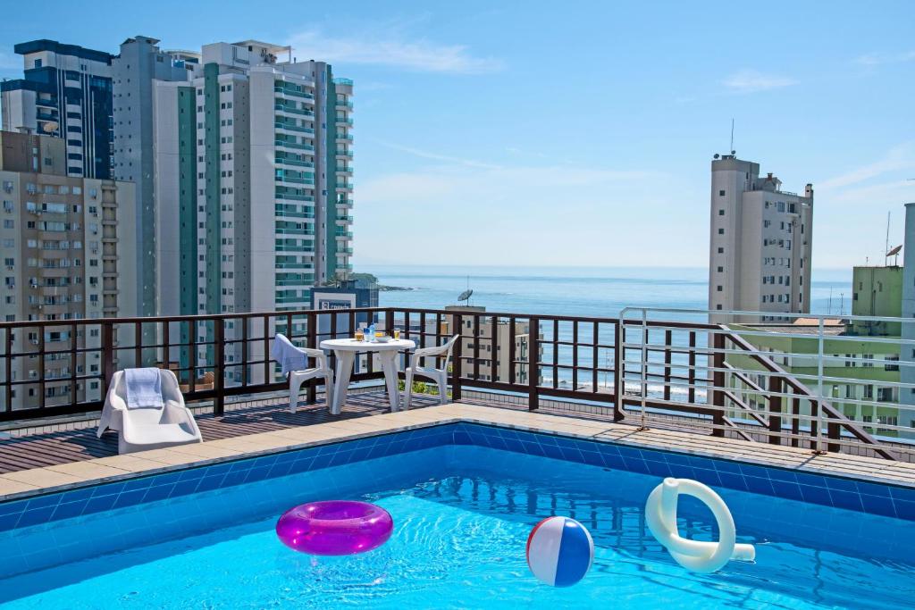 Atobá Praia Hotel في باليريو كامبوريو: مسبح على شرفة مبنى