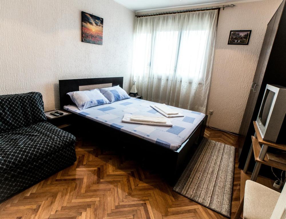 a small bedroom with a bed and a couch at Apartman Stankovic in Arandelovac