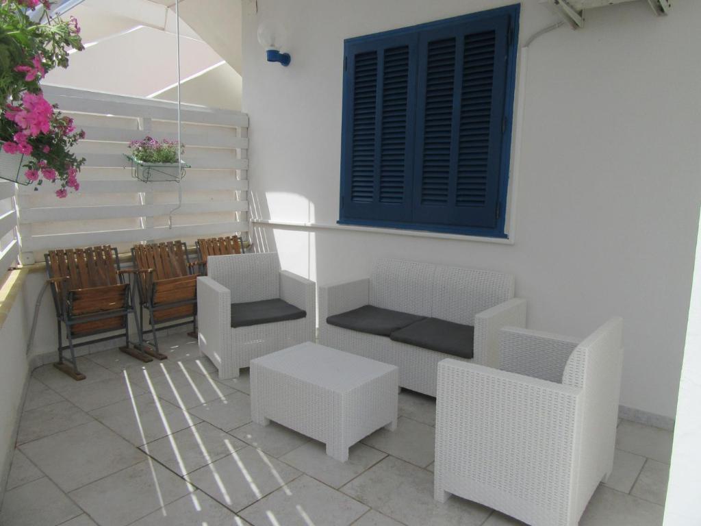 a patio with chairs and a table and a window at Villa Oltremare in Punta Prosciutto