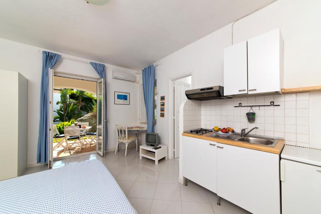 eine Küche mit weißen Schränken und Blick auf einen Innenhof in der Unterkunft Casa Agave in Ischia
