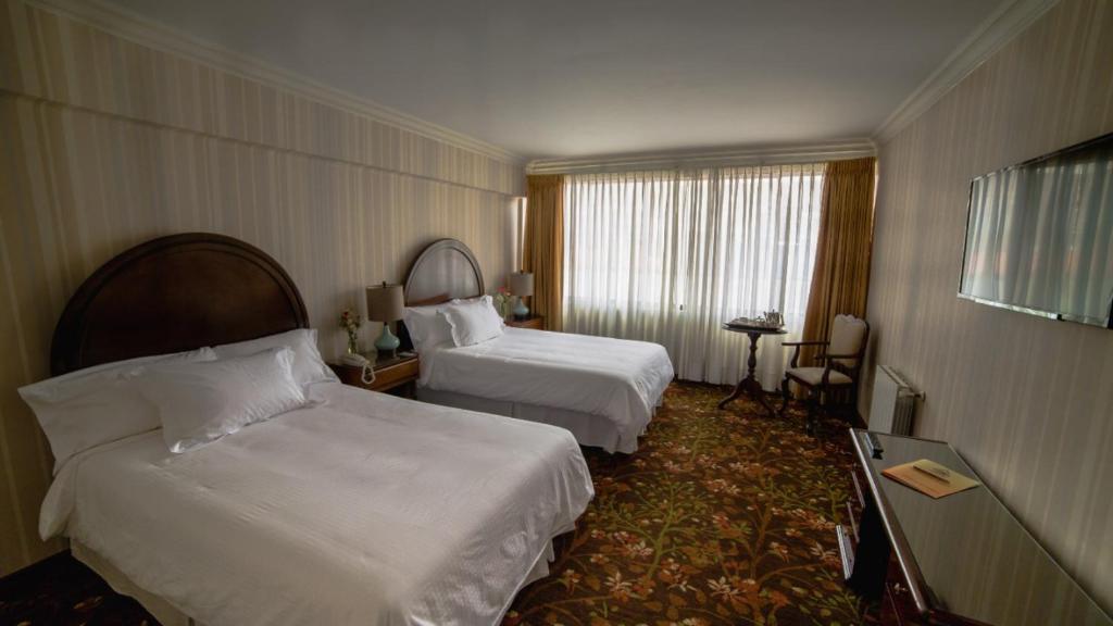 a hotel room with two beds and a window at Hotel Coloso Potosi in Potosí