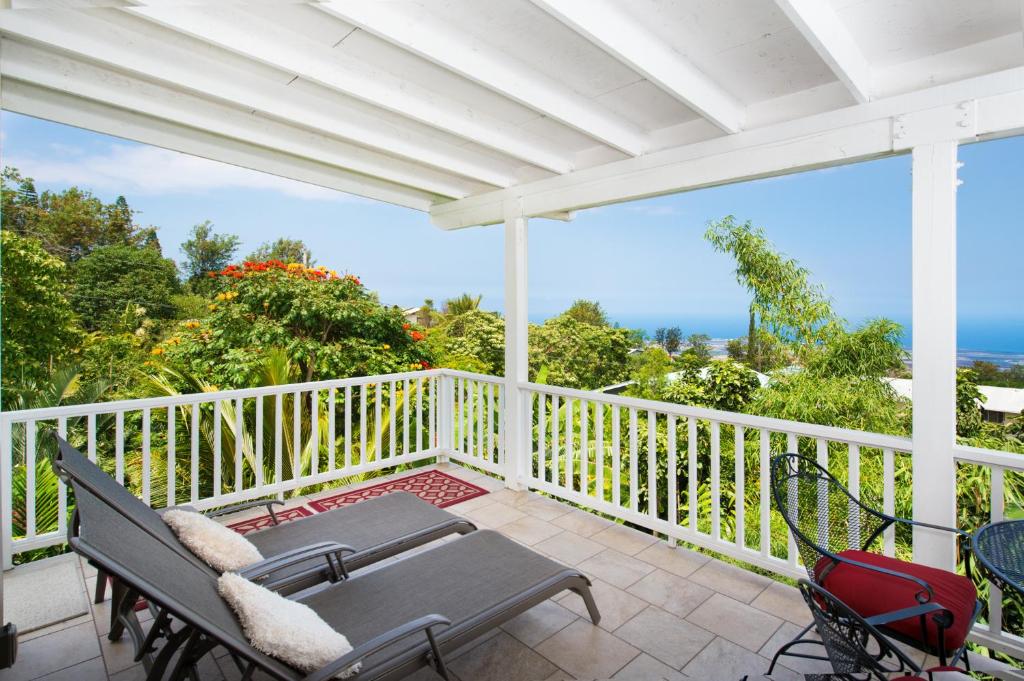 a patio with a table and chairs on a balcony at Bears' Place Guest House in Kailua-Kona