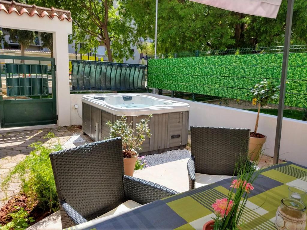 een patio met een tafel en stoelen en een hot tub bij Apartment Lemon Tree in Split
