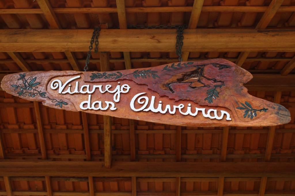 una señal colgada del techo de un edificio en Pousada Vilarejo das Oliveiras, en Queimada