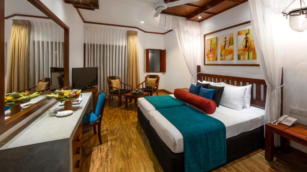 a hotel room with a bed and a dining room at Tangerine Beach Hotel in Kalutara