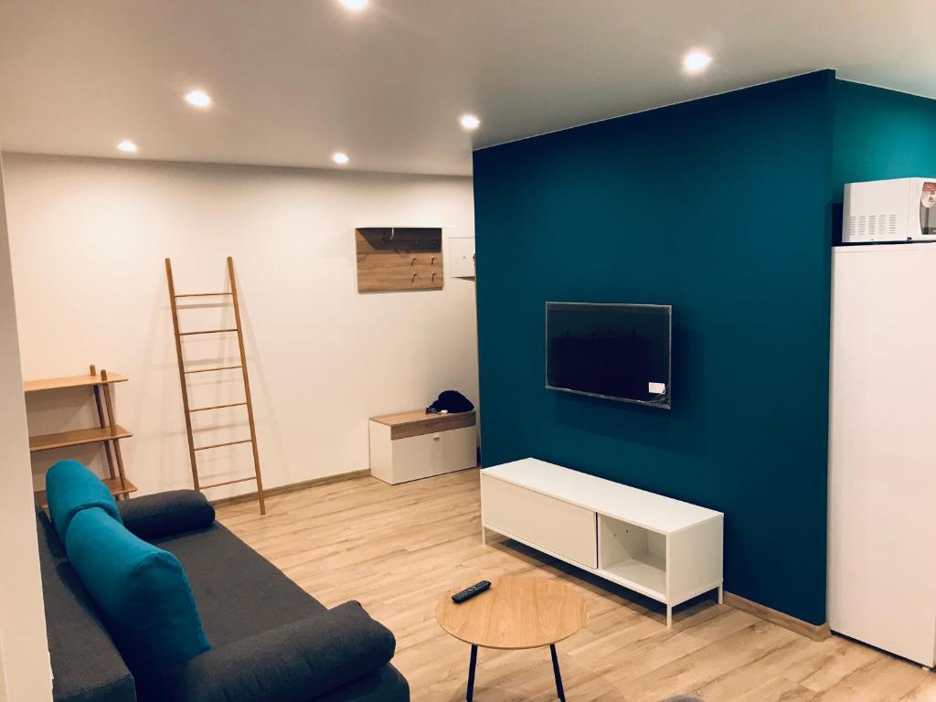 un soggiorno con parete blu e TV di TF Apartment двокімнатні апартаменти в центрі міста a Poltava
