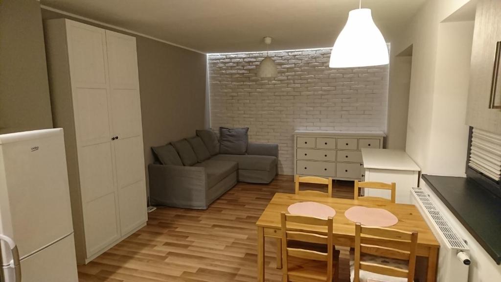 een keuken en een woonkamer met een bank en een tafel bij Nowy apartament Bydgoszcz centrum in Bydgoszcz