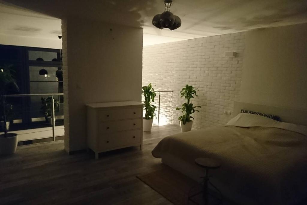 a bedroom with a bed and a brick wall at Apartament Loft 100 m2 Centrum Bydgoszcz in Bydgoszcz
