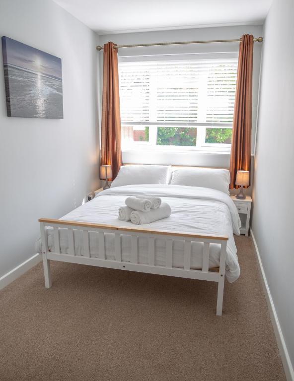 a white bed in a bedroom with a window at Sea Road Apartments in Bournemouth