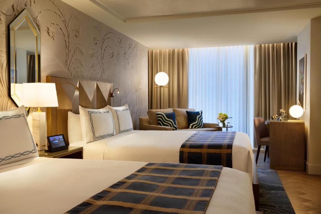a hotel room with two beds and a desk at EXchange Hotel Vancouver in Vancouver