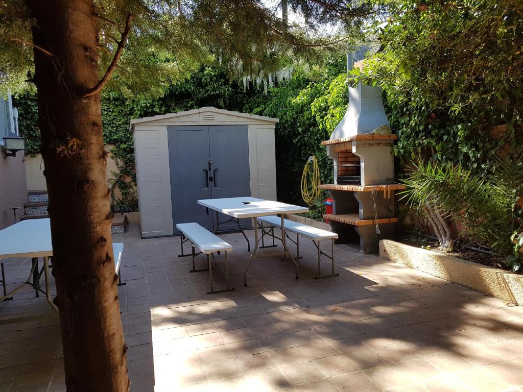 un patio con mesa, sillas y un cobertizo en Verdaguer Home, en Castelldefels