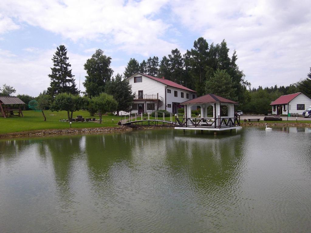 eine Brücke über einen See mit einem Haus im Hintergrund in der Unterkunft Kure Guesthouse in Rahinge