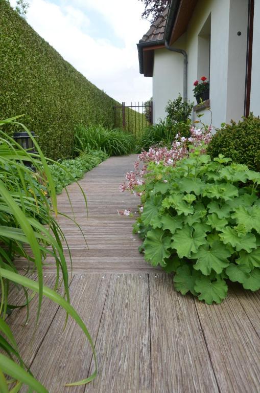 a wooden walkway with plants on the side of a house at La Coulonnière in Wismes