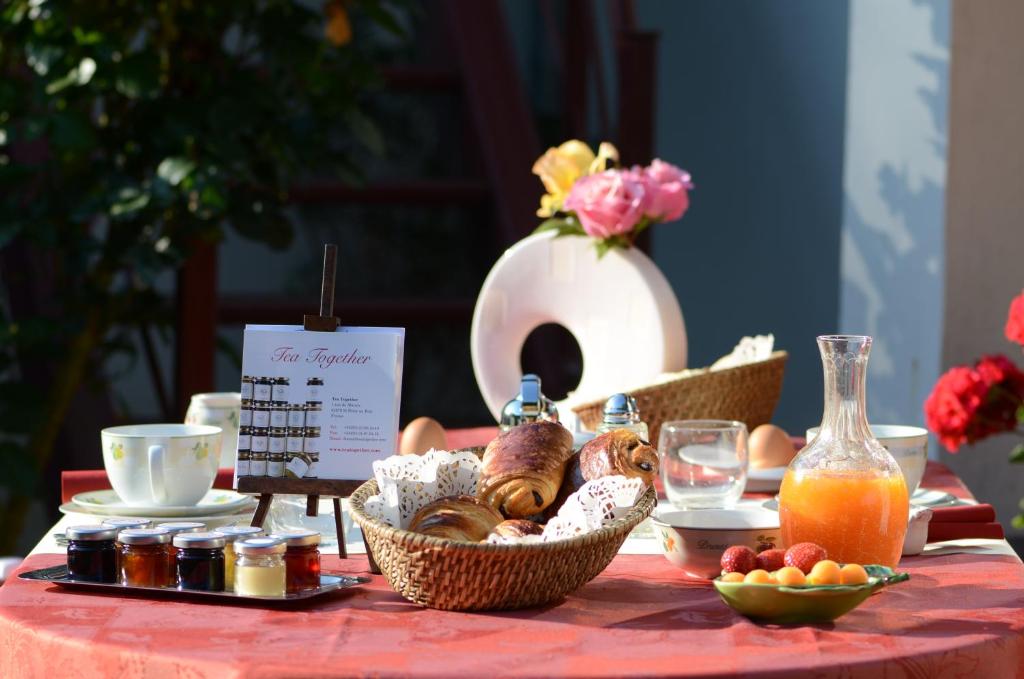 a table topped with baskets of bread and juice at La Coulonnière in Wismes