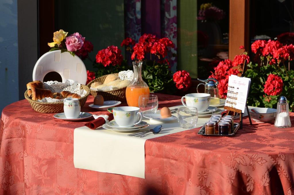 a table with a red table cloth with food on it at La Coulonnière in Wismes