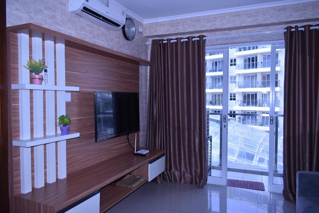 万隆Gateway Pasteur 2BR tower depan Ruby 7 C的一间带电视和大窗户的客厅